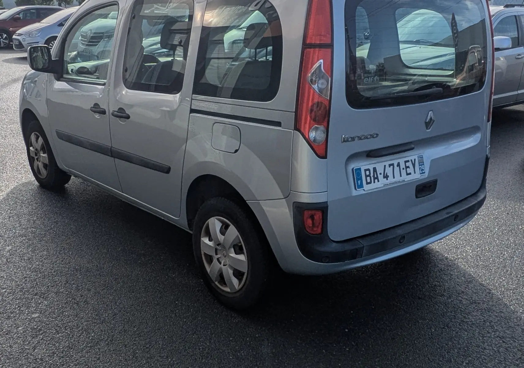 Vue 3/4 arrière droite d'un Renault Kangoo bleu ciel avec portes latérales coulissantes sur un parking.
