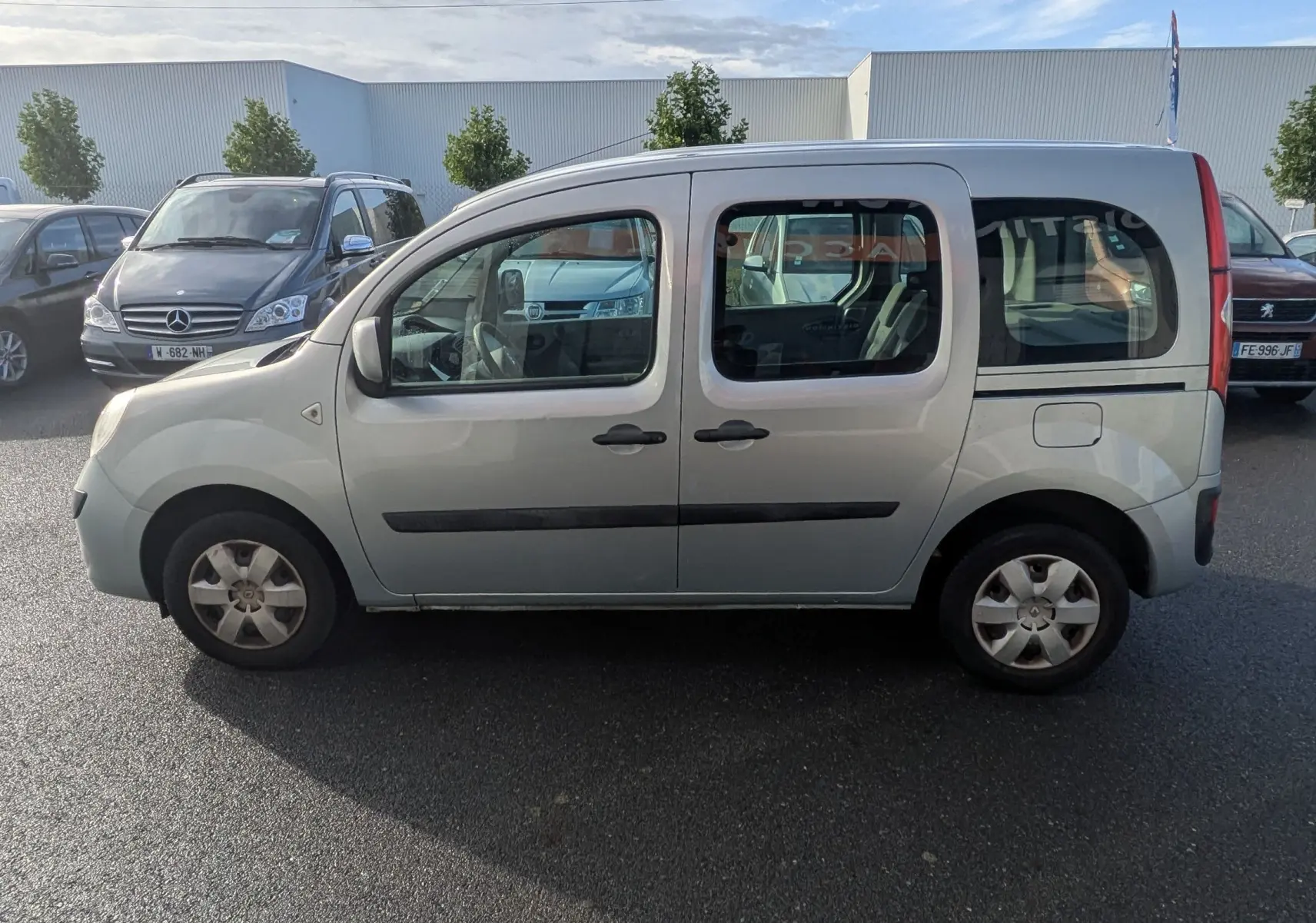 Profil côté gauche d'un Renault Kangoo II bleu ciel avec portes coulissantes et vitres arrière teintées.