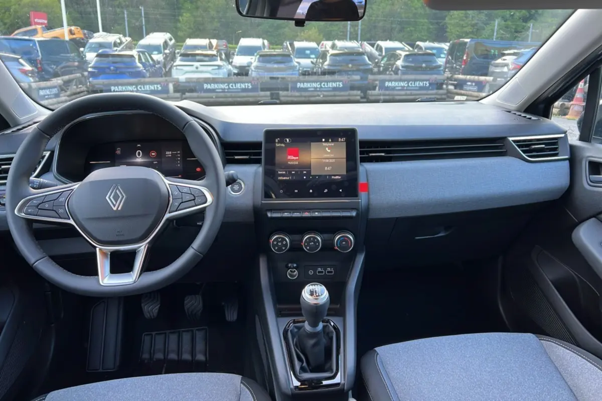 Vue intérieure avant de la Renault Clio DCI 100 Evolution gris schiste, avec volant multifonction et boîte manuelle.