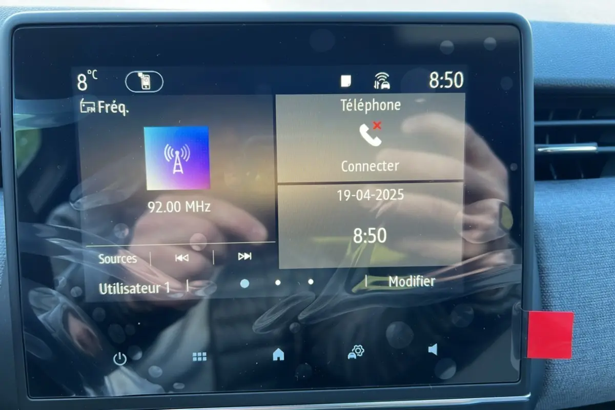 Écran tactile central de la Renault Clio DCI 100 Evolution Camera 2025 affichant radio et téléphone, intérieur gris schiste.