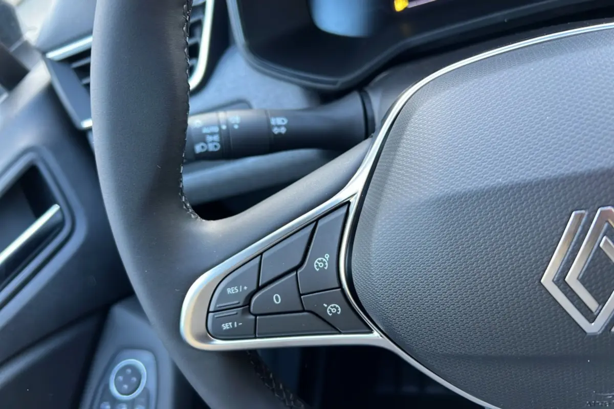 Gros plan sur le volant de la Renault Clio DCI 100 Evolution Camera 2025, montrant les commandes de régulateur de vitesse.