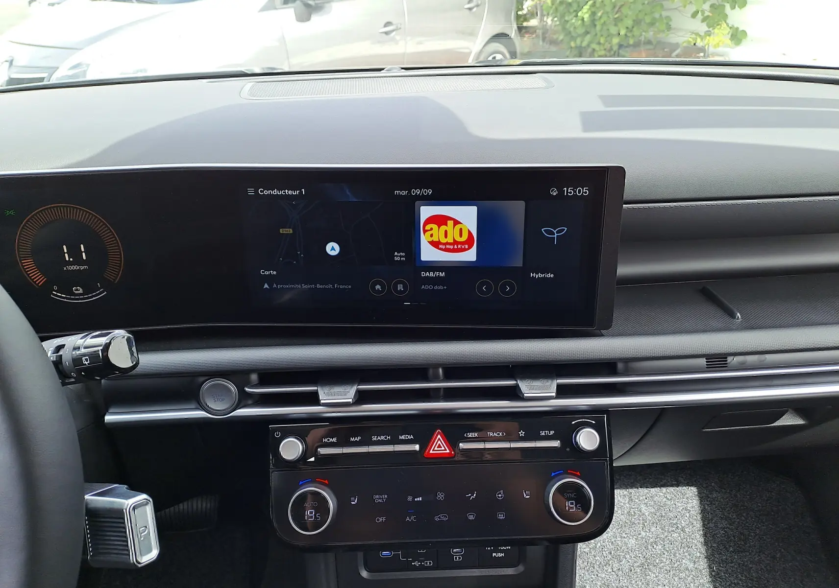 Tableau de bord du Hyundai Tucson 2025 en vue frontale, écran tactile affichant radio DAB et commandes climatisation digitales.