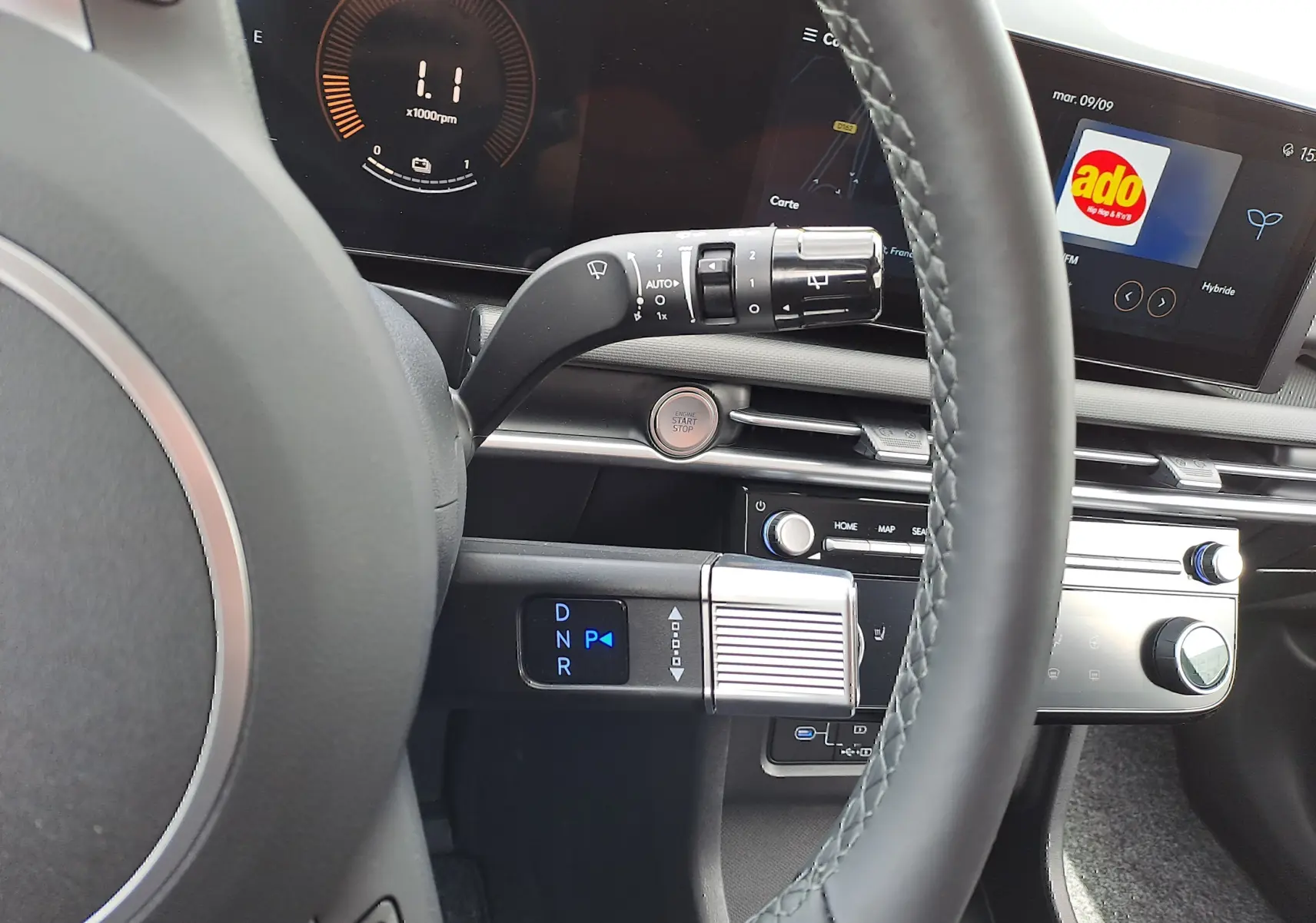 Intérieur du Hyundai Tucson 2025, vue sur le volant et la console centrale avec écran tactile et levier de vitesses digital.