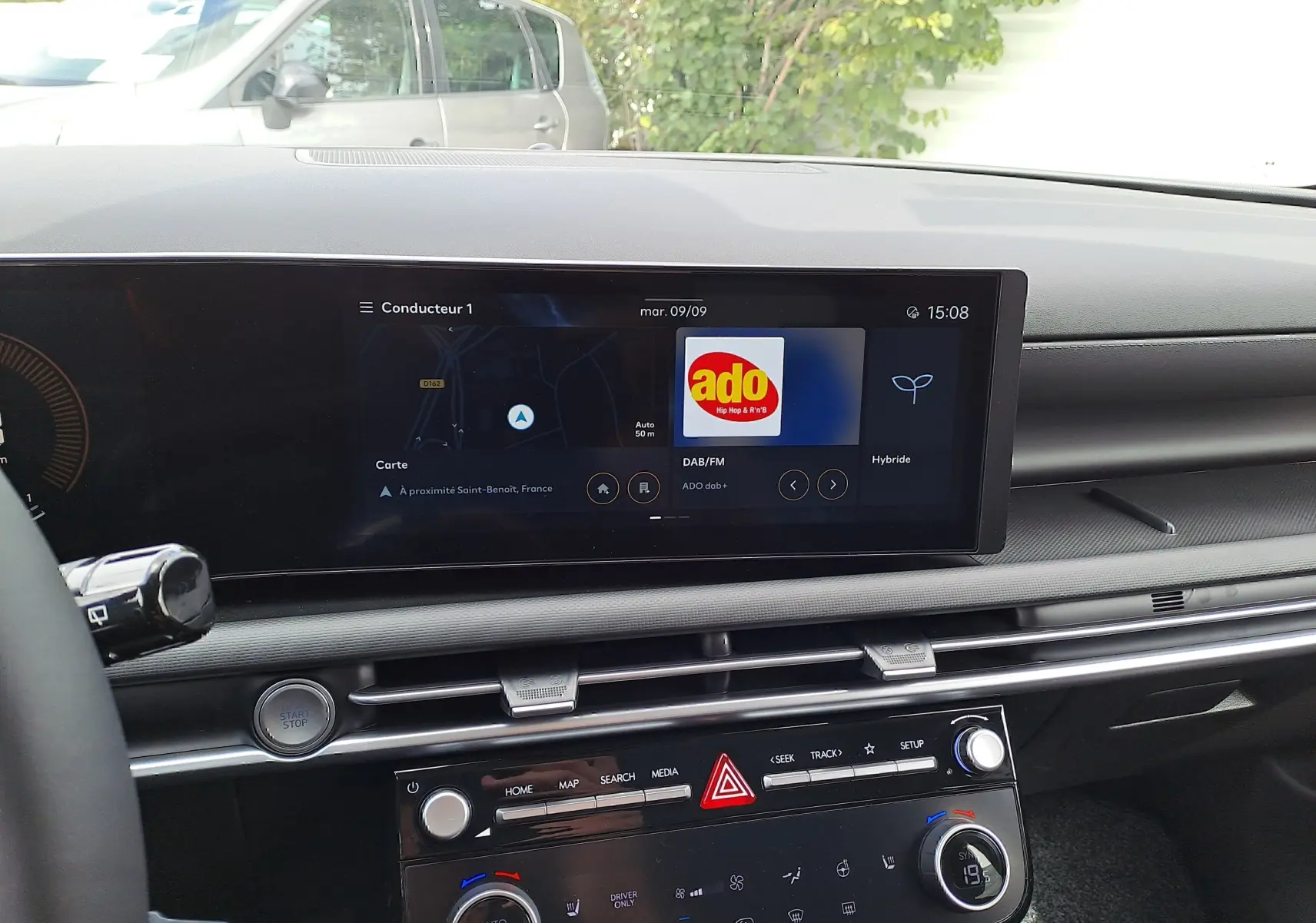 Tableau de bord du Hyundai Tucson 2025 en gris, vue centrée sur l'écran tactile et commandes climatisation.