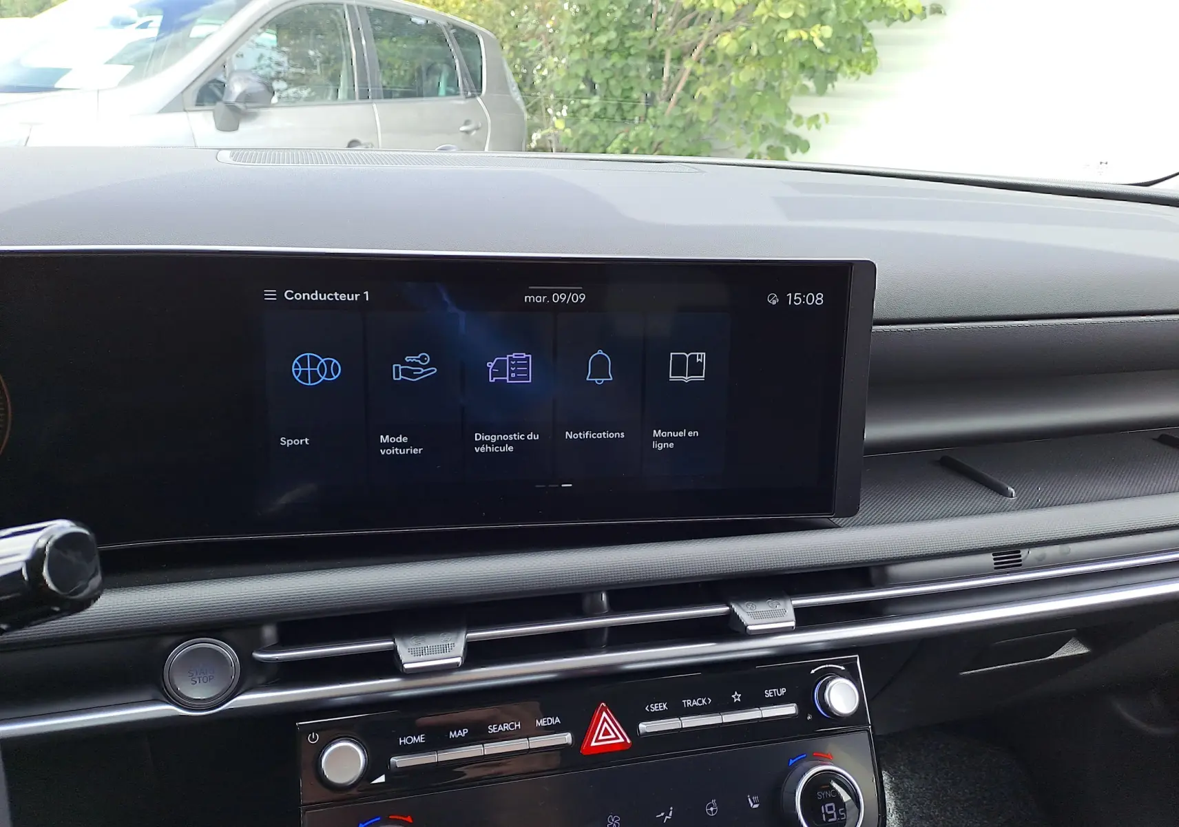 Tableau de bord du Hyundai Tucson 2025 en gris Ecotronic, vue intérieure centrée sur l'écran tactile et commandes climatiques.