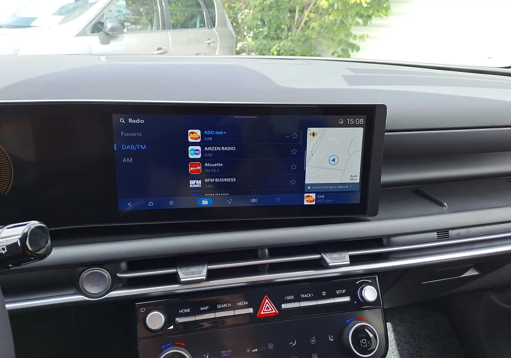 Tableau de bord noir du Hyundai Tucson 2025 avec écran tactile affichant la radio DAB et commandes climatisation.