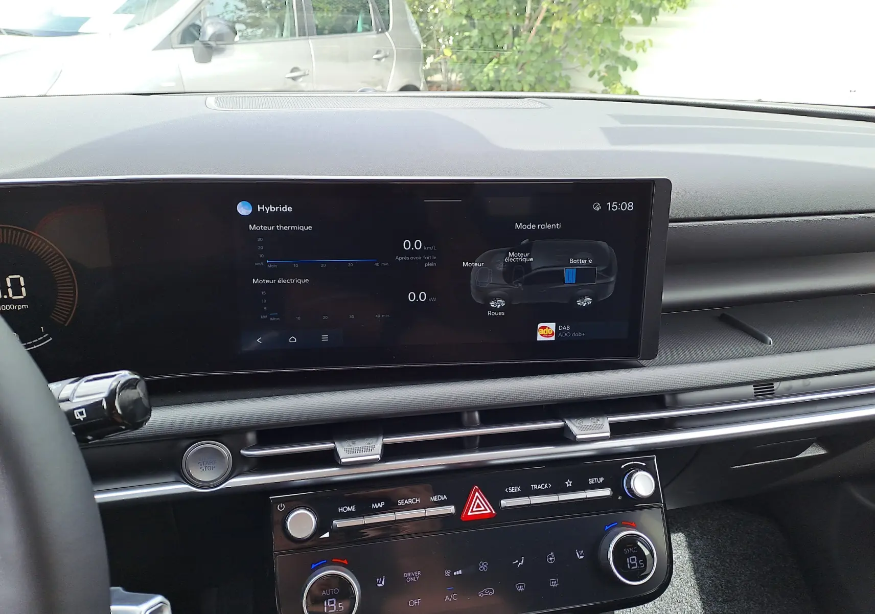 Tableau de bord du Hyundai Tucson 2025 hybride, affichage digital central avec infos moteur thermique et électrique, intérieur noir.