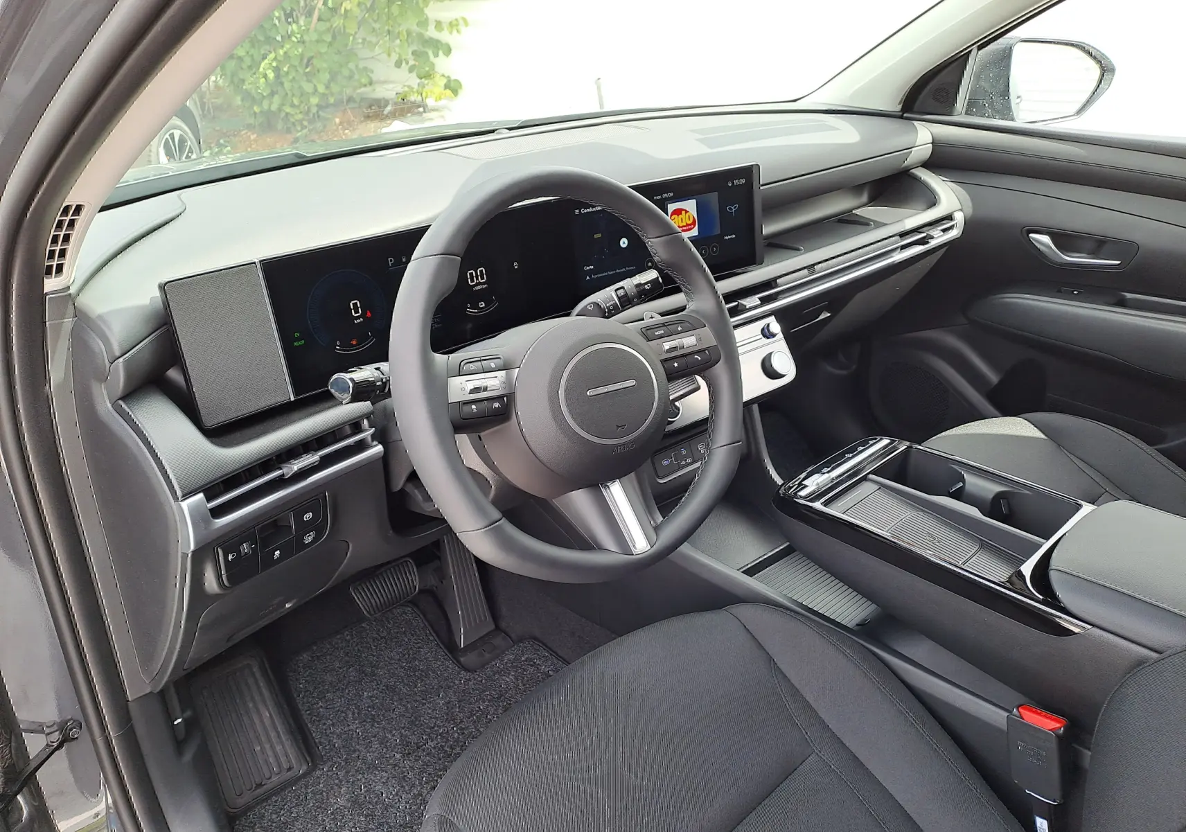 Intérieur noir du Hyundai Tucson 2025, vue côté conducteur montrant tableau de bord numérique et console centrale moderne.