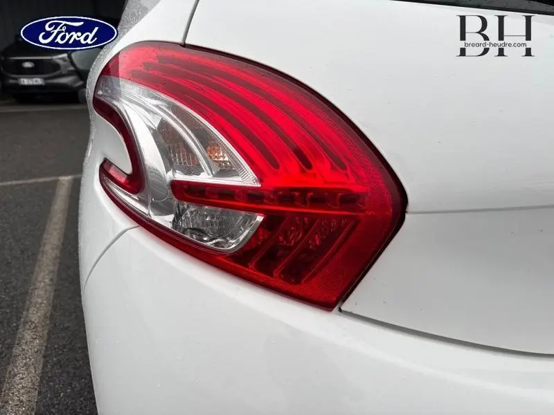 Gros plan sur le feu arrière droit rouge d'une Peugeot 208 blanche Banquise, soulignant la finition lisse de la carrosserie.