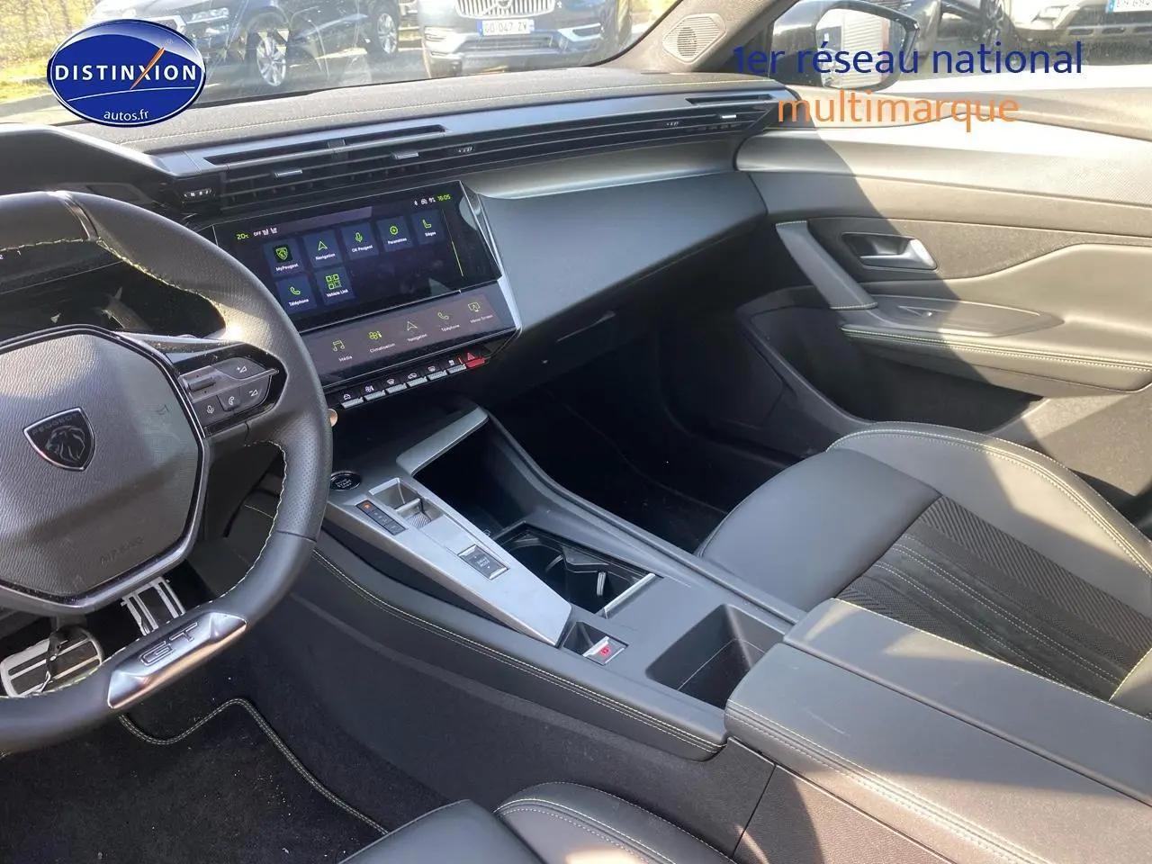 Intérieur noir de la Peugeot 408 Hybrid 145 GT e-dcs6, vue côté conducteur avec tableau de bord et écran tactile.
