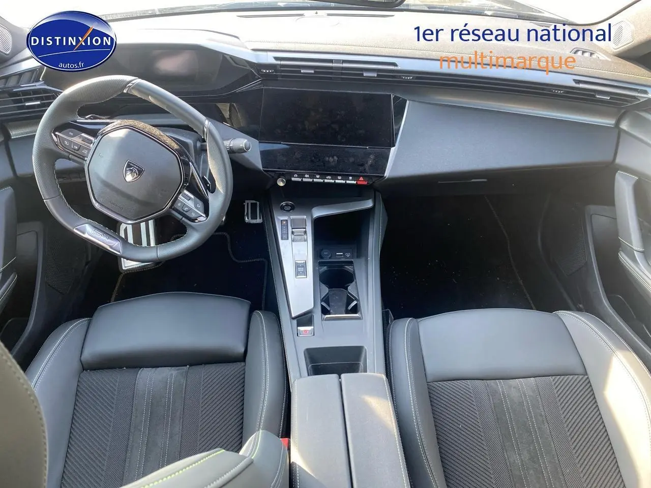 Vue intérieure plongeante du poste de conduite noir du Peugeot 408 Hybrid 145 GT avec volant cuir et écran tactile central.