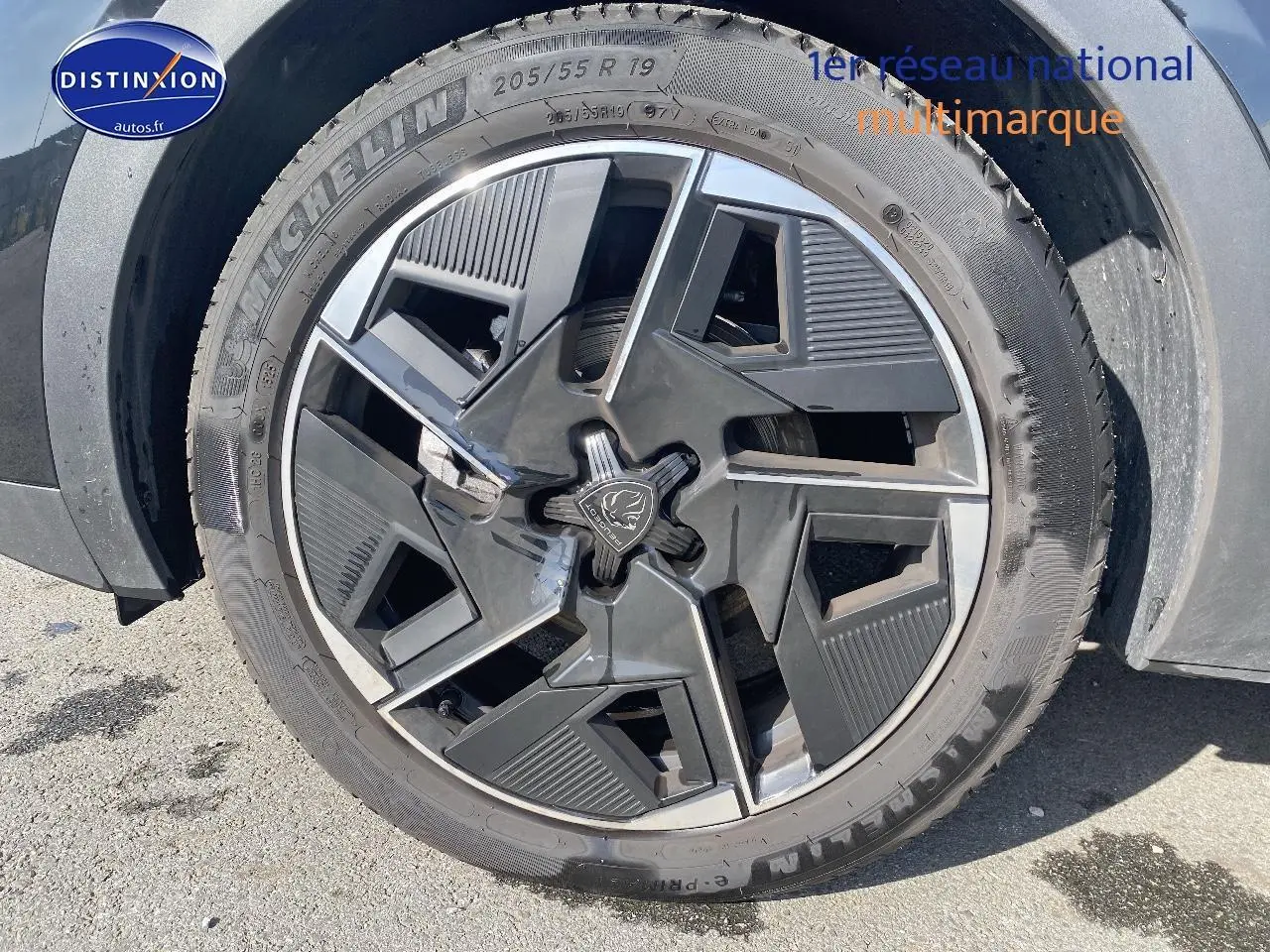 Gros plan sur la jante alu noire au design géométrique du Peugeot 408 Hybrid 145 GT e-dcs6 noir, roue avant droite.