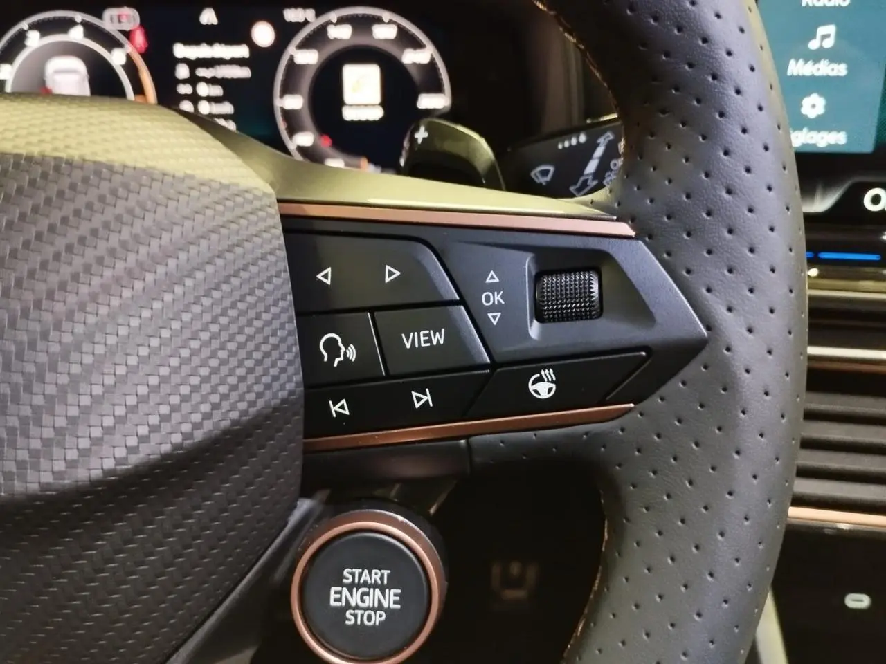 Gros plan sur le volant perforé noir avec commandes et bouton start/stop cuivré du CUPRA Formentor Magnetic Tech.