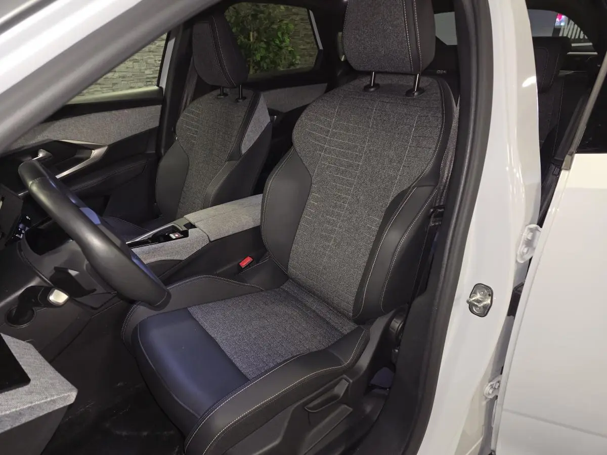 Intérieur avant droit du Peugeot 3008 blanc 2025, sièges tissu gris et cuir noir avec surpiqûres Quartz.