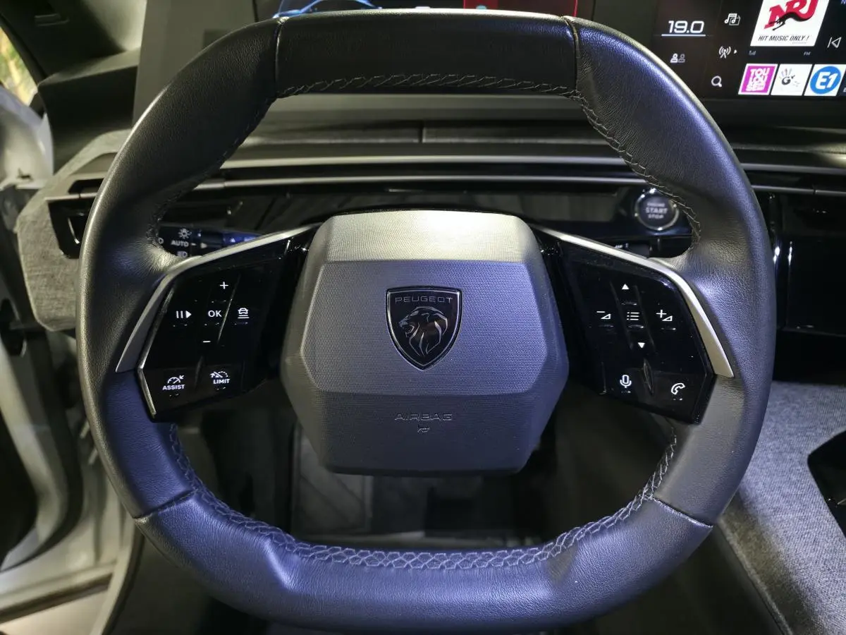 Volant compact cuir noir avec logo Peugeot au centre, commandes intégrées, vue rapprochée de l'intérieur du Peugeot 3008 2025.