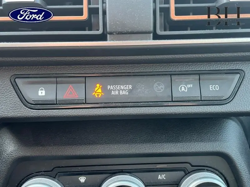 Vue rapprochée du tableau de bord de la Dacia Sandero blanche, montrant les boutons de sécurité et mode ECO allumé.