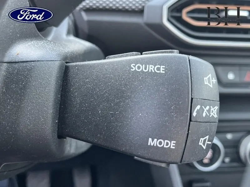 Levier de commande audio noir en gros plan à gauche du volant, intérieur d'une Dacia Sandero blanc Glacier 2023.