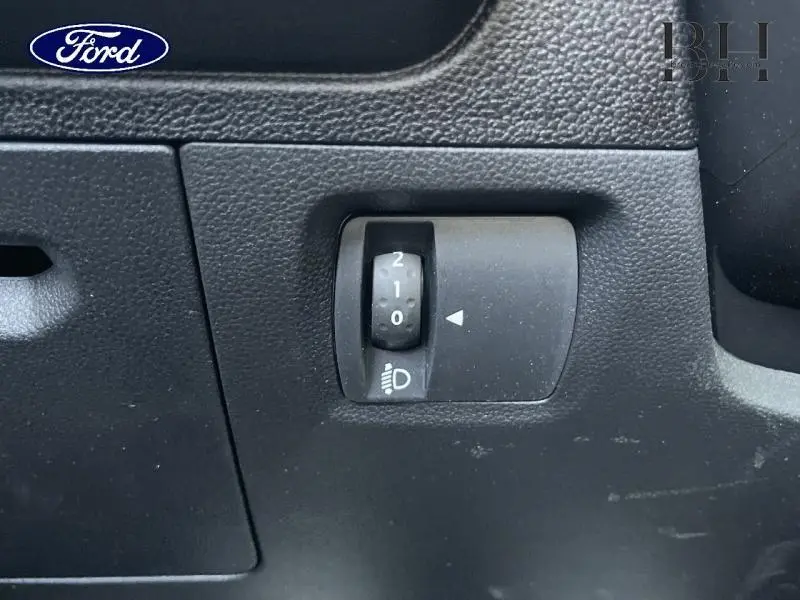 Réglage de l'inclinaison des phares sur le tableau de bord noir d'une Dacia Sandero blanche 2023.