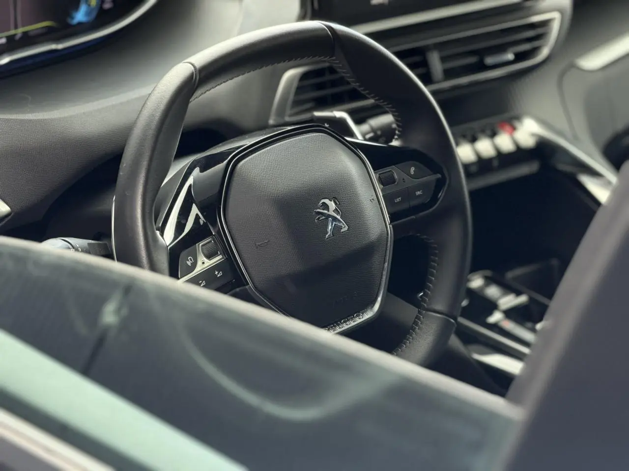 Vue rapprochée du volant cuir noir Mistral du Peugeot 3008 Plug-in Hybrid 2024 avec commandes intégrées.