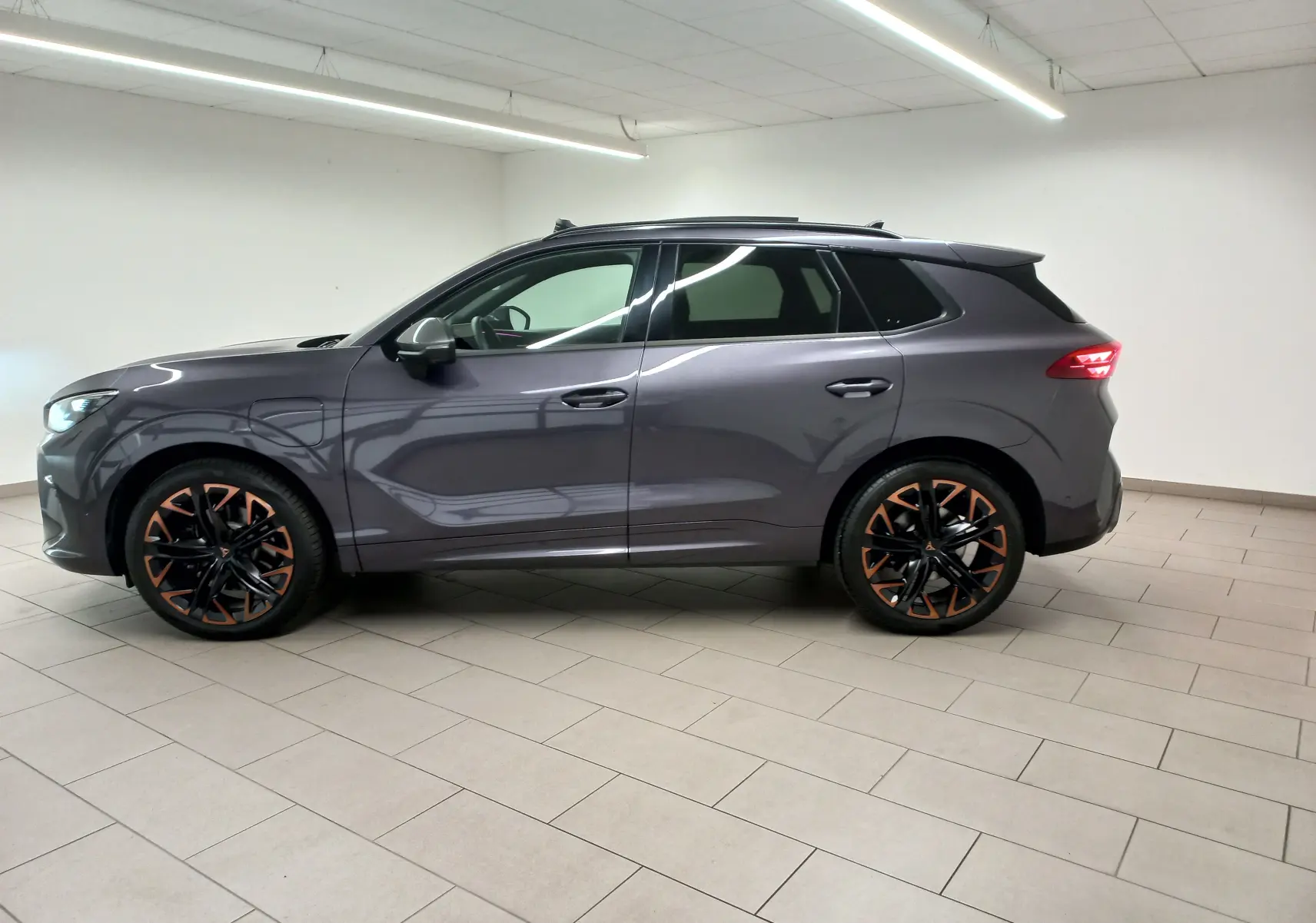 Vue de profil côté gauche du SUV CUPRA TERRAMAR violet intersidéral avec jantes cuivrées et toit ouvrant panoramique.