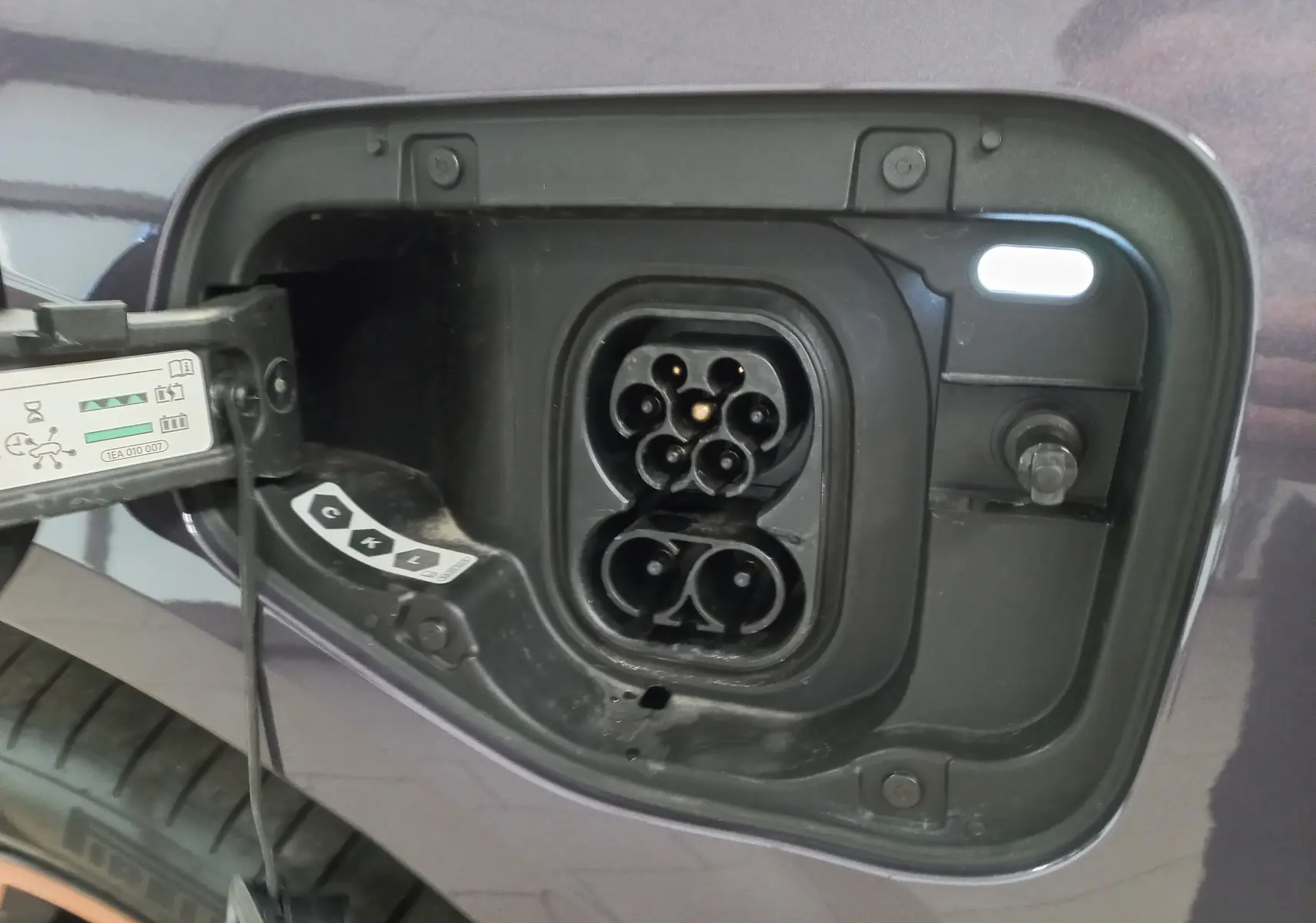 Prise de recharge ouverte côté gauche sur CUPRA TERRAMAR violet intersidéral, montrant le connecteur hybride rechargeable.
