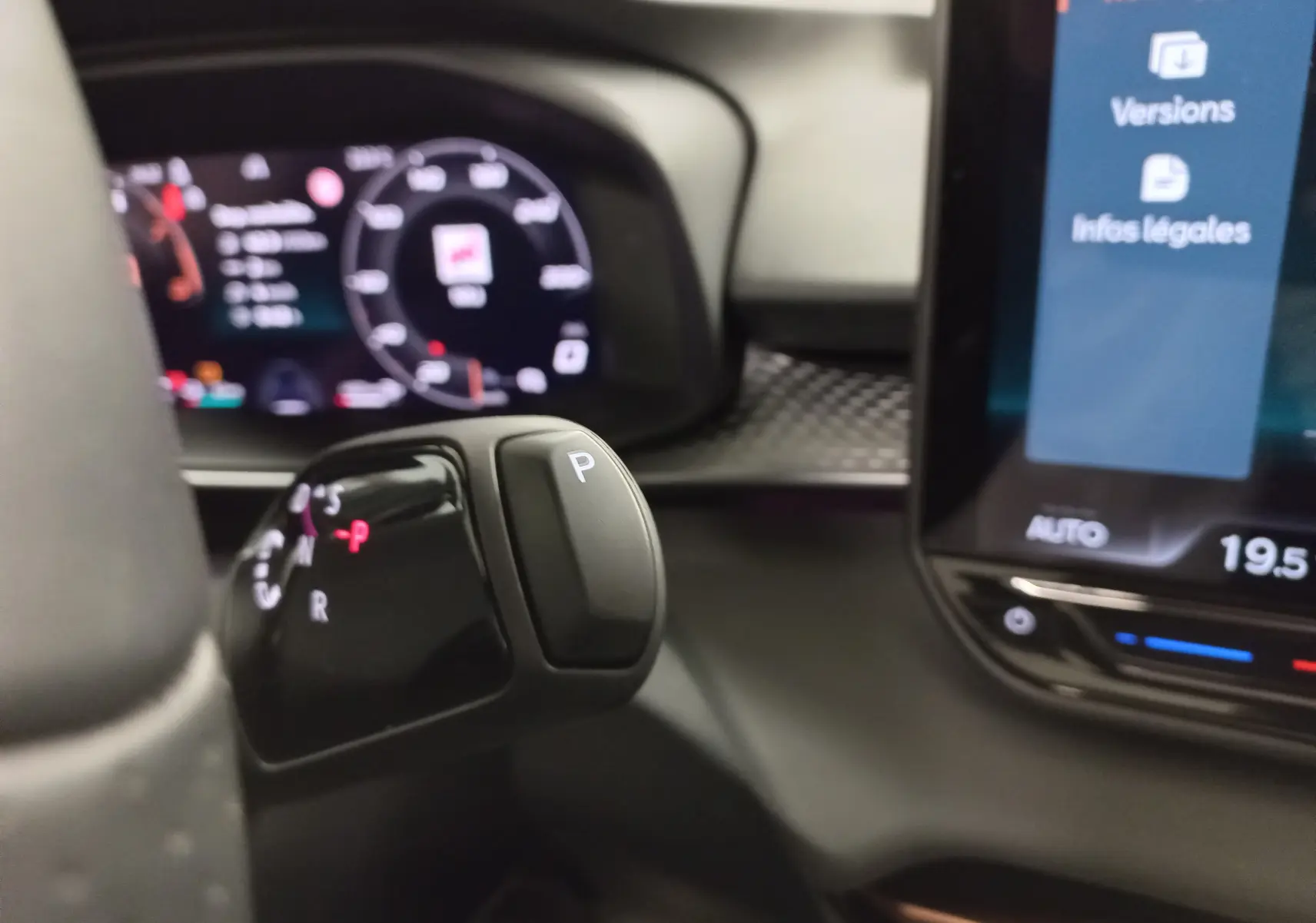Le levier de boîte automatique en gros plan dans l'habitacle du CUPRA TERRAMAR 1.5 eHYBRID 2025, affichage numérique en arrière-plan.