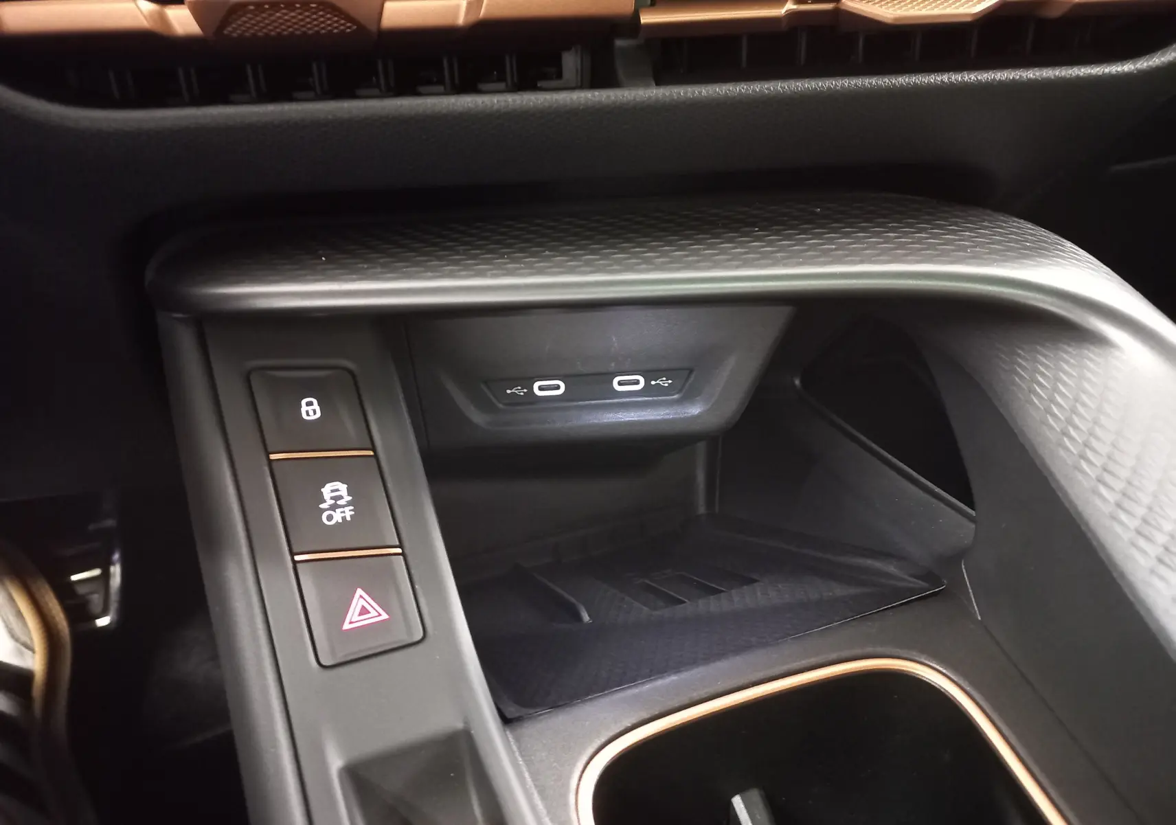 Gros plan intérieur sur la console centrale du CUPRA TERRAMAR 2025, avec ports USB-C et finition noire texturée.