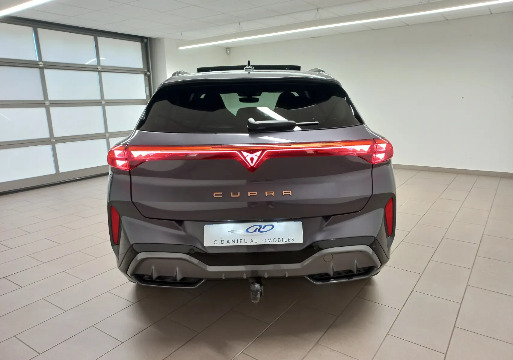 Vue arrière d'une CUPRA TERRAMAR violet intersidéral avec feux LED continus et attelage escamotable visible.