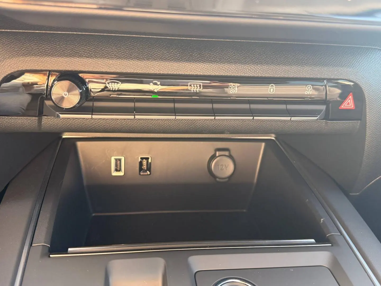 Vue rapprochée de la console centrale noire avec commandes climatisation, ports USB et prise 12V dans Citroën C5 Aircross gris Platinium.