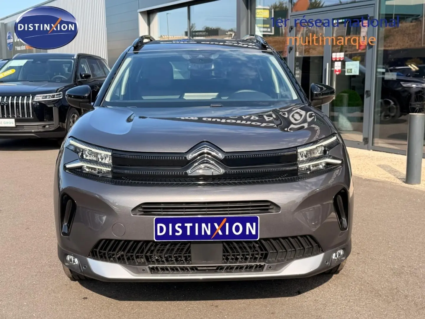 Vue avant d'un Citroën C5 Aircross gris Platinium 2025 avec calandre distinctive et barres de toit visibles.