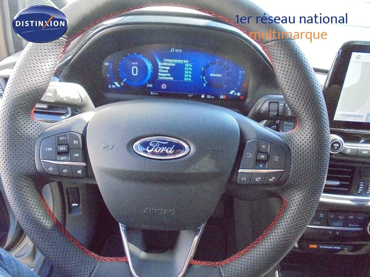 Vue rapprochée du volant perforé avec surpiqûres rouges et tableau de bord digital du Ford Puma gris Solar Metal 2022.