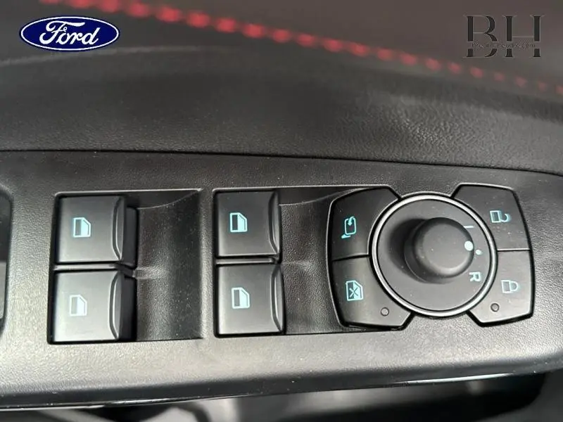 Gros plan sur les commandes de lève-vitres et réglage des rétroviseurs côté conducteur du Ford Puma gris Solar 2025.