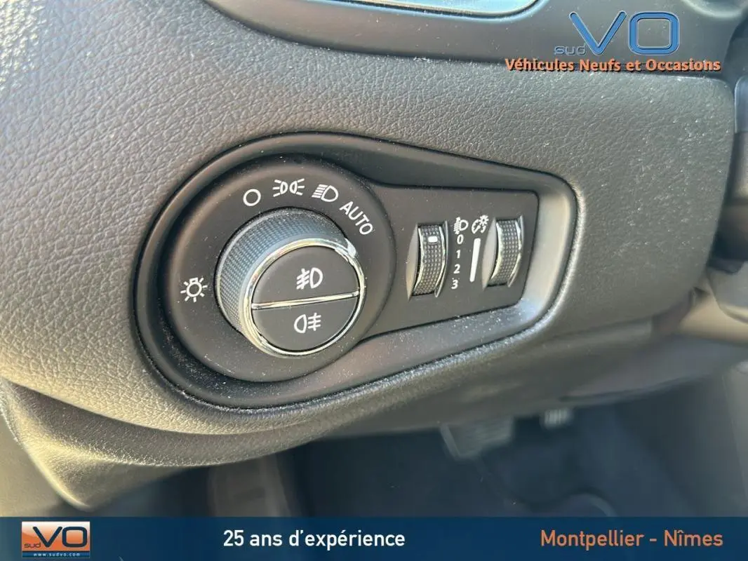 Gros plan sur le bouton de commande des phares du Jeep Renegade noir 2024, montrant les réglages d'éclairage et antibrouillard.