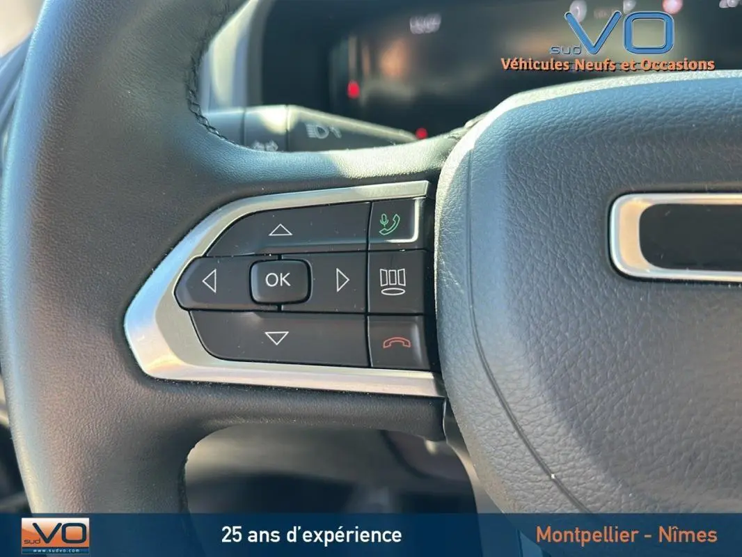 Gros plan sur les commandes gauche du volant noir du Jeep Renegade 2024, avec boutons multifonctions et finition argentée.