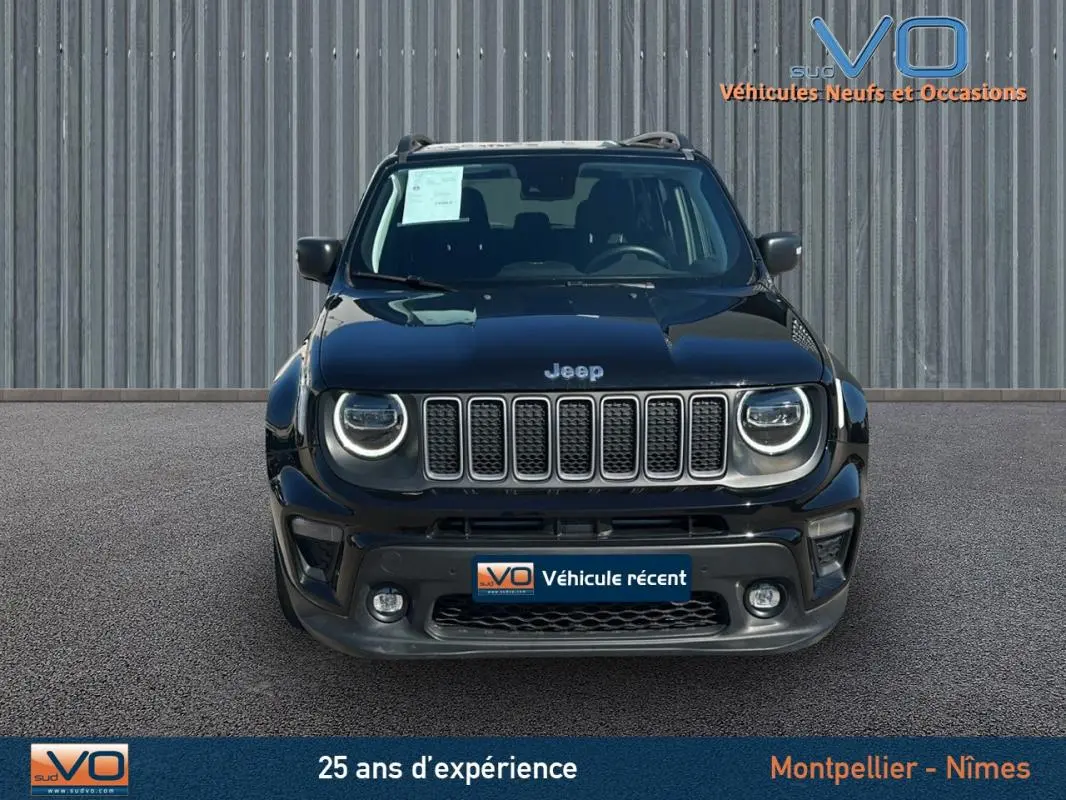 Vue frontale d'un Jeep Renegade noir 2024 avec phares LED ronds et barres de toit visibles sur fond industriel.