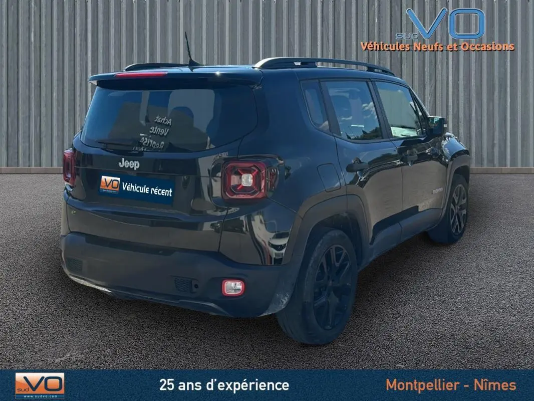 Jeep Renegade noir vue 3/4 arrière droit avec barres de toit et jantes alliage 18 pouces sur sol bitumé.