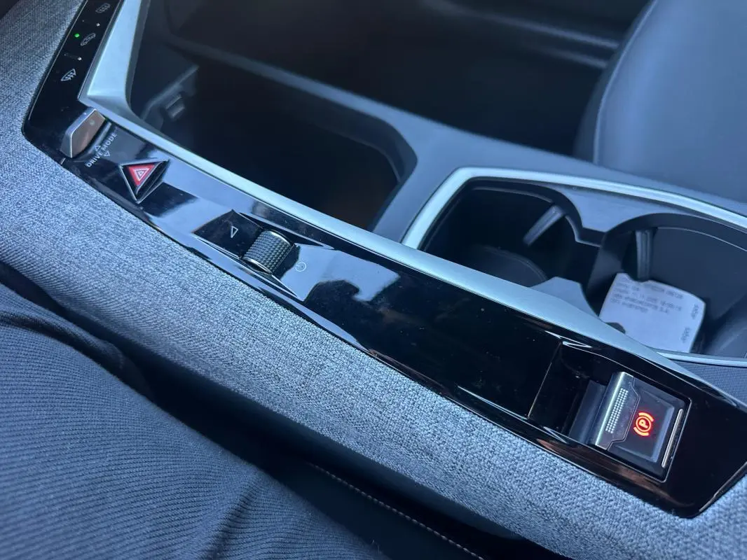 Vue rapprochée de la console centrale du Peugeot 3008 Hybrid 145 Allure 2025, avec frein à main électrique activé.
