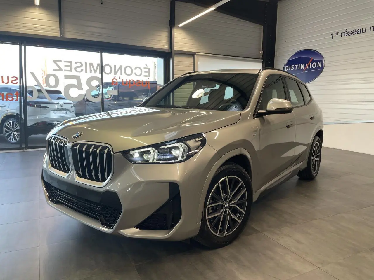 BMW X1 xDrive 20d 2024 en Spacesilber metallic, vue 3/4 avant avec calandre imposante et jantes 18 pouces M Sport.