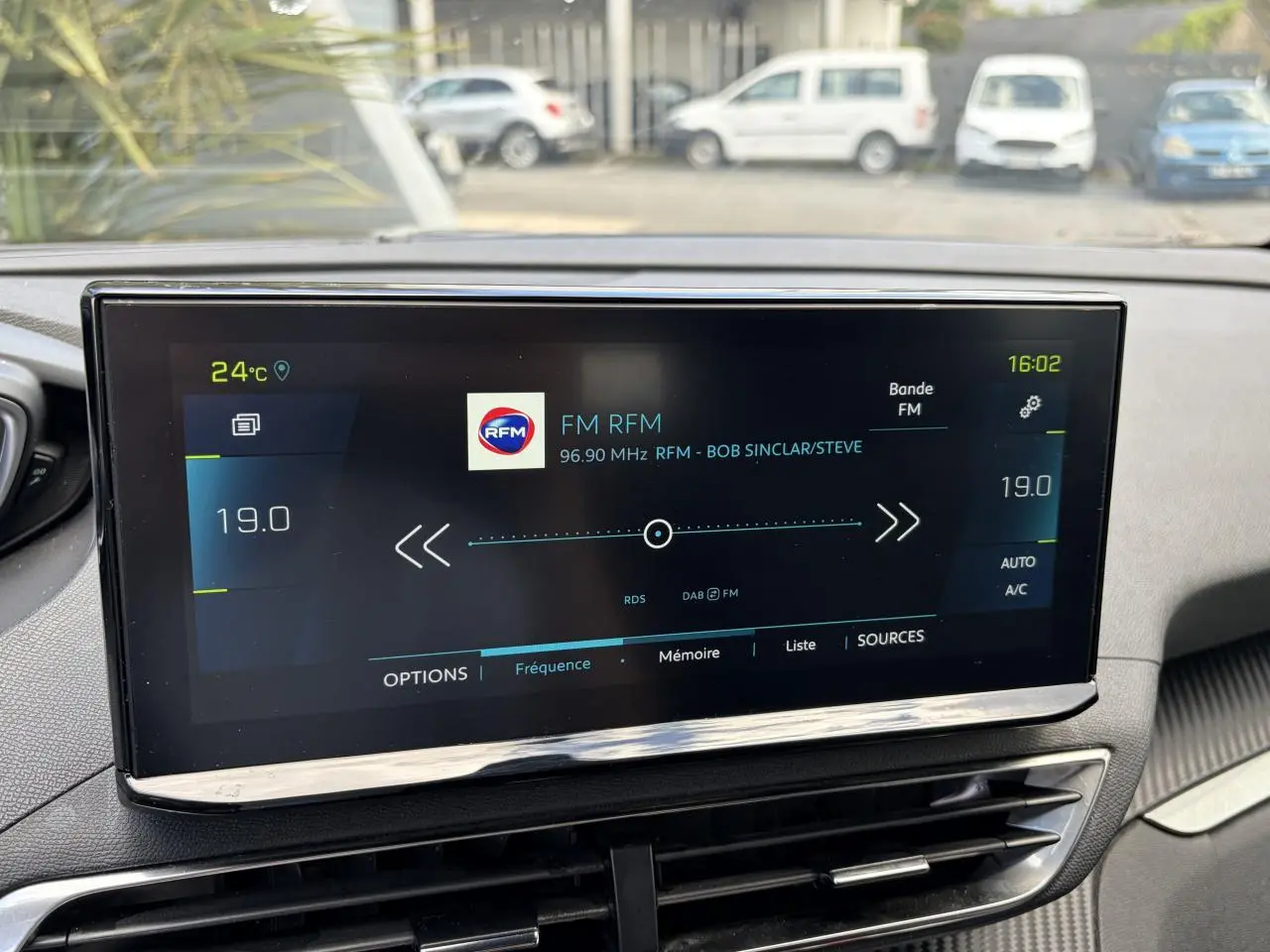 Écran tactile central du Peugeot 3008 Plug-in Hybrid affichant la radio FM RFM, vue intérieure avant.