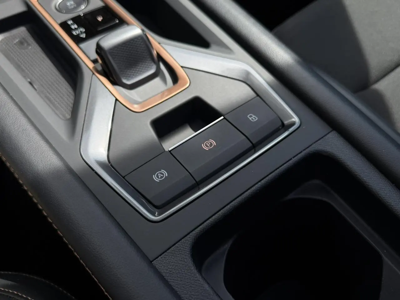 Gros plan sur la console centrale noire du CUPRA Formentor blanc avec levier de vitesse et boutons de frein à main électronique.