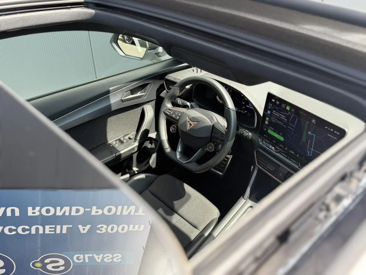 Vue intérieure côté conducteur du CUPRA Formentor 2025, volant cuir noir avec logo, écran tactile et tableau de bord digital.