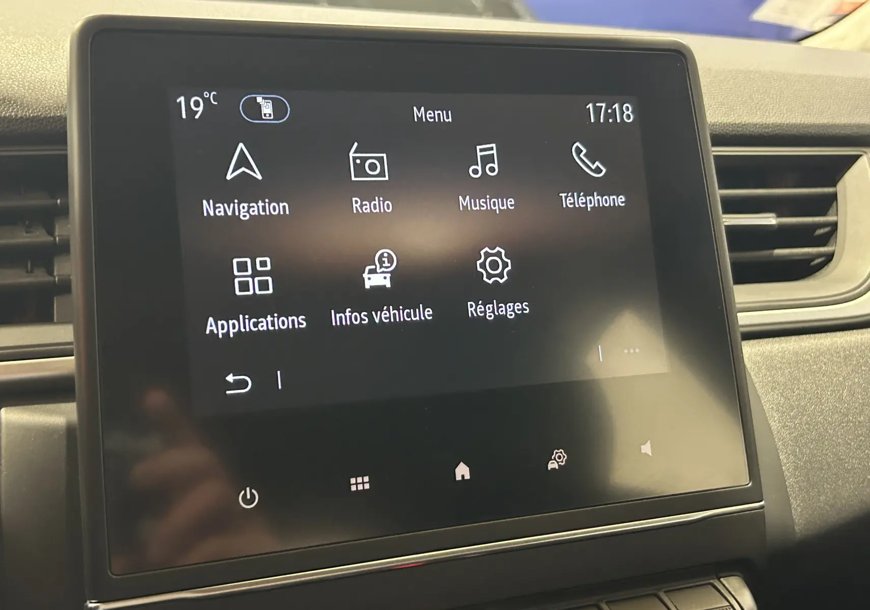 Écran tactile central du Renault Captur gris 2022 affichant le menu principal avec navigation, radio et téléphone.