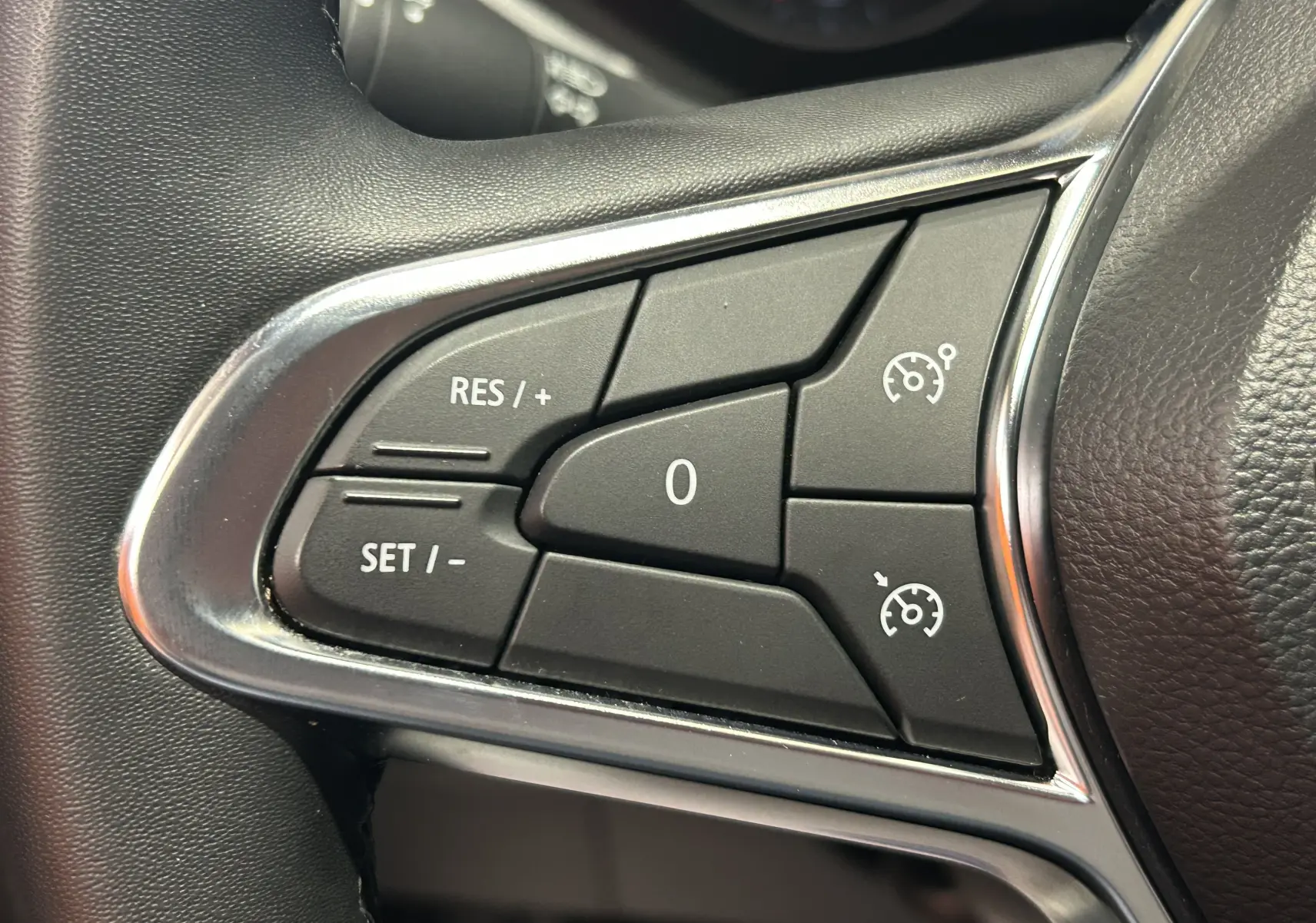 Gros plan sur les commandes de régulateur de vitesse au volant du Renault Captur gris, finition 2022.