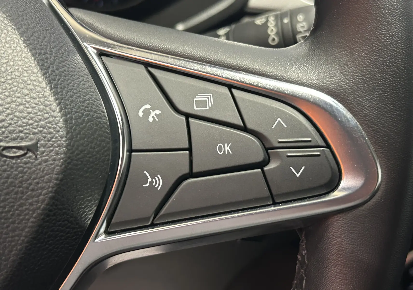 Gros plan sur les commandes multifonctions noires du volant côté droit du Renault Captur gris 2022.
