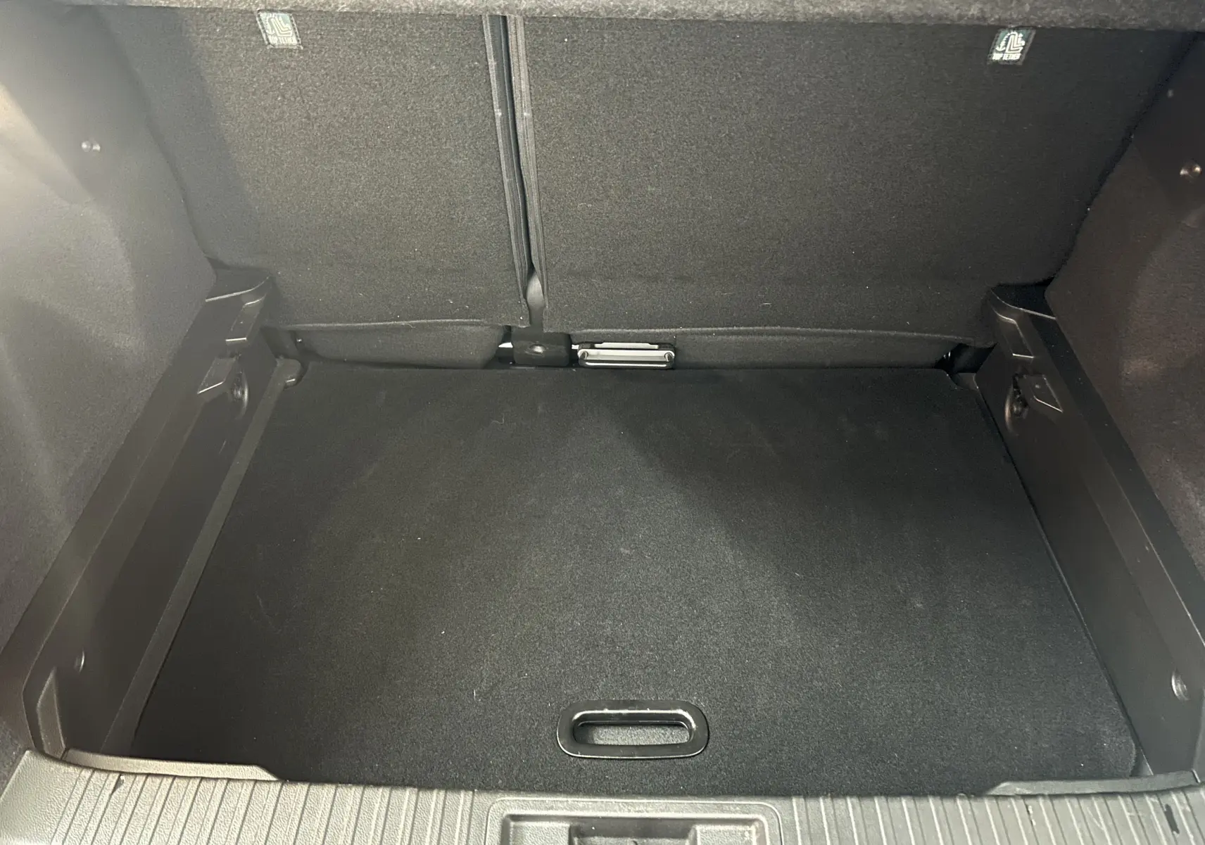 Coffre vide en vue plongeante d'un Renault Captur gris 2022, soulignant son espace de rangement propre et bien fini.