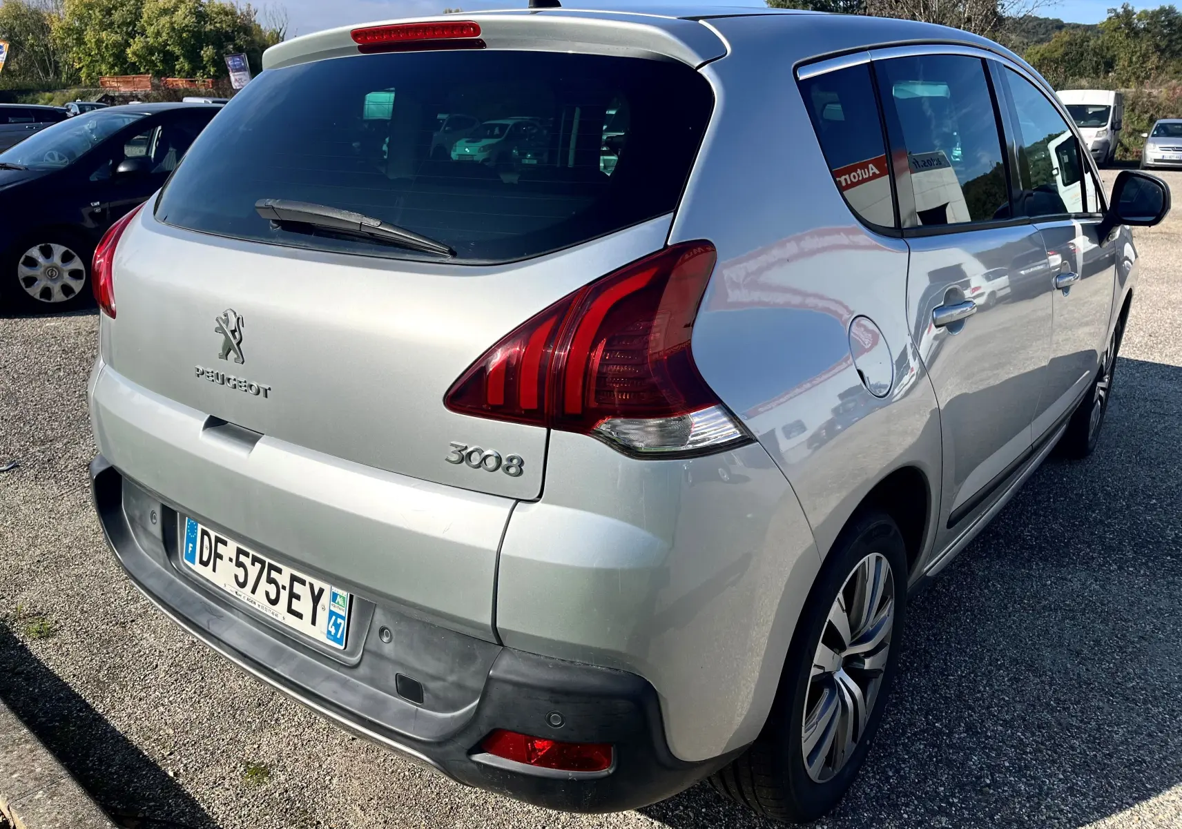 Vue 3/4 arrière droit d'un Peugeot 3008 gris clair de 2014 avec feux arrière rouges et plaque française visible.