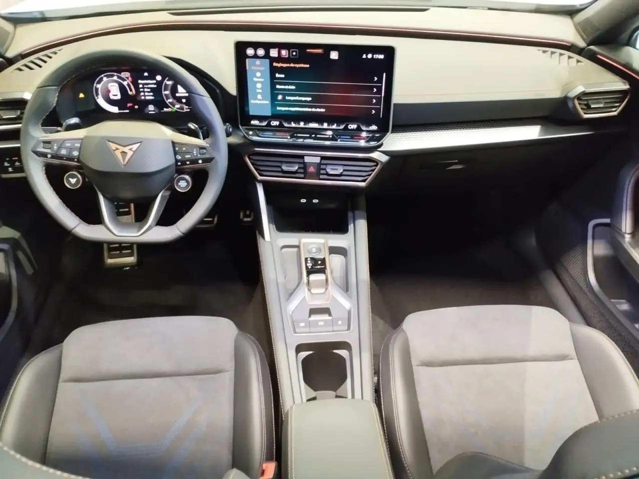 Intérieur CUPRA Formentor vue avant, sièges suédine noir et bleu, tableau de bord noir avec écran tactile central.