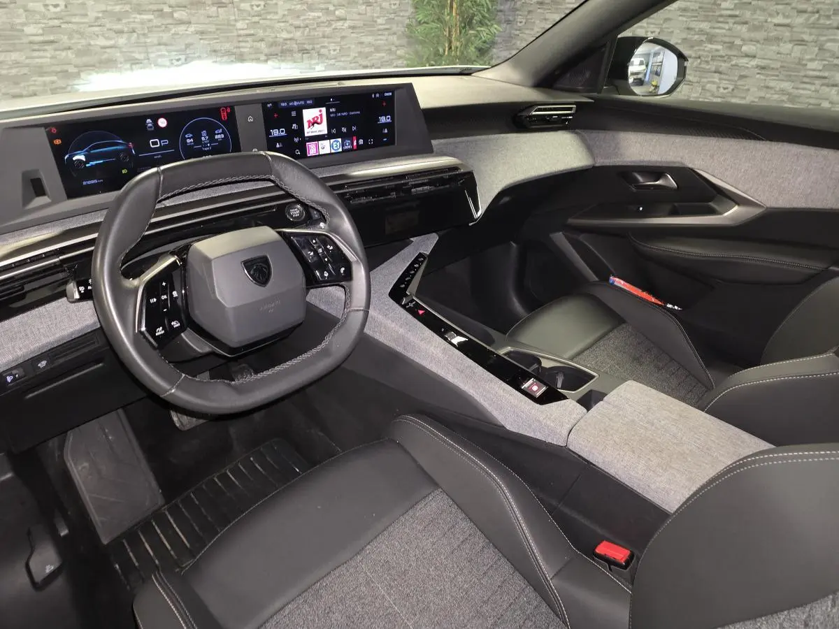 Intérieur du Peugeot 3008 2025 vu côté conducteur, volant compact cuir noir et tableau de bord numérique panoramique.