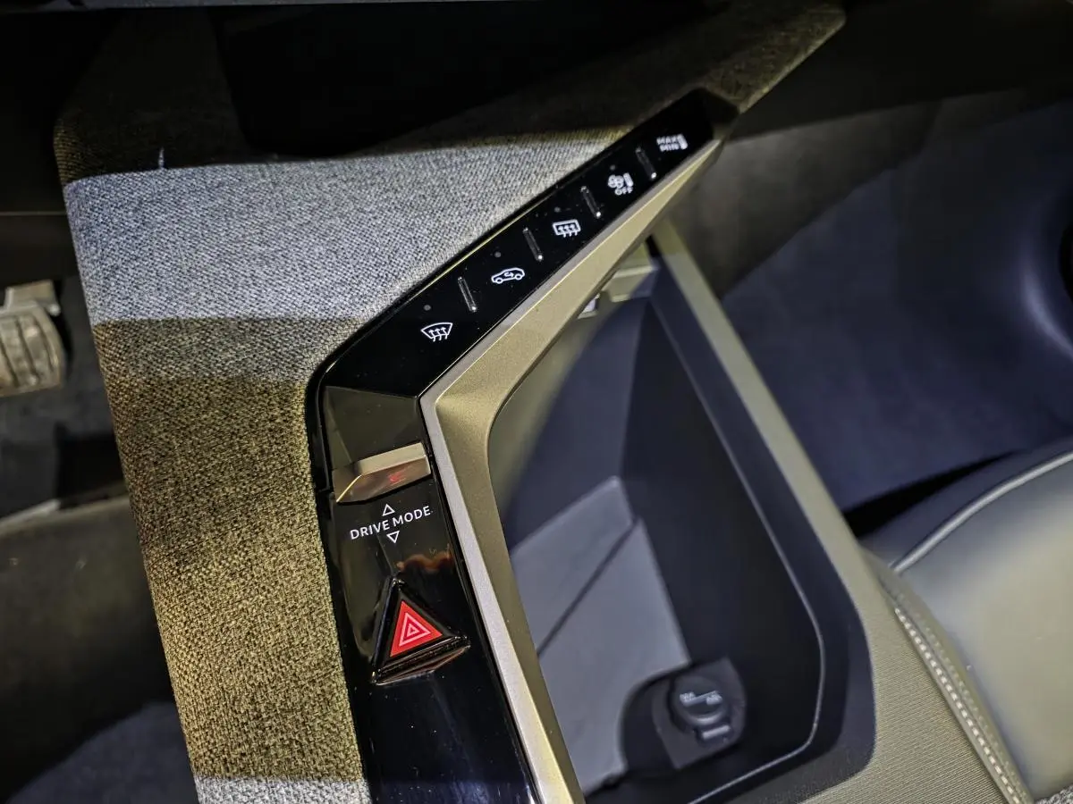 Gros plan sur la console centrale du Peugeot 3008 blanc 2025, avec bouton Drive Mode et tissu gris chiné.