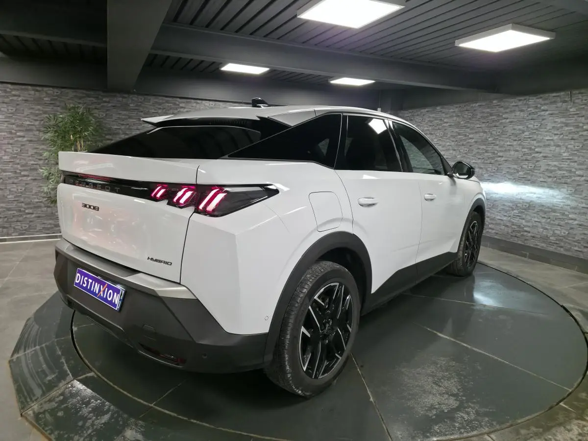 Peugeot 3008 hybride blanc vue 3/4 arrière droit, feux arrière LED 3 griffes et jantes alliage noires.